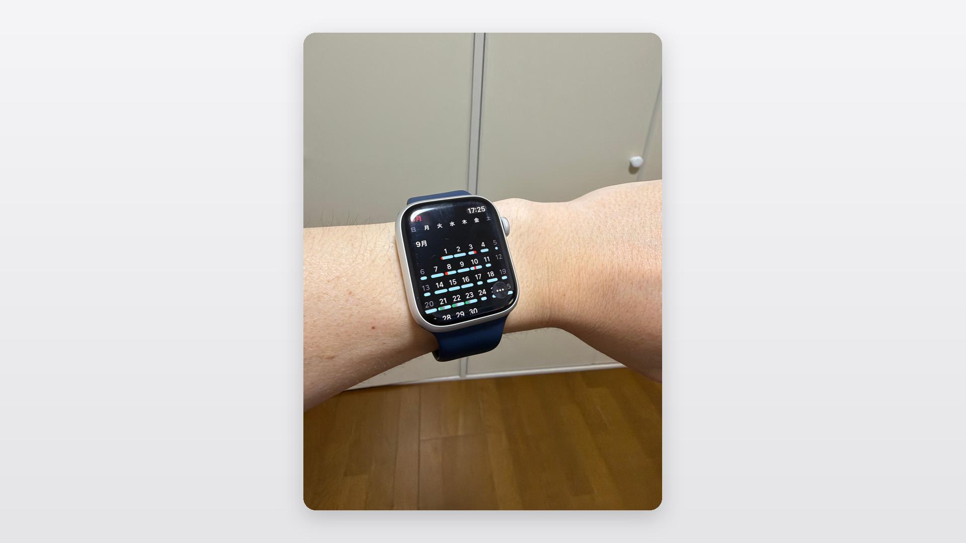 手首に装着したApple Watchの画面に、カレンダーの月表示が開かれている実機写真
